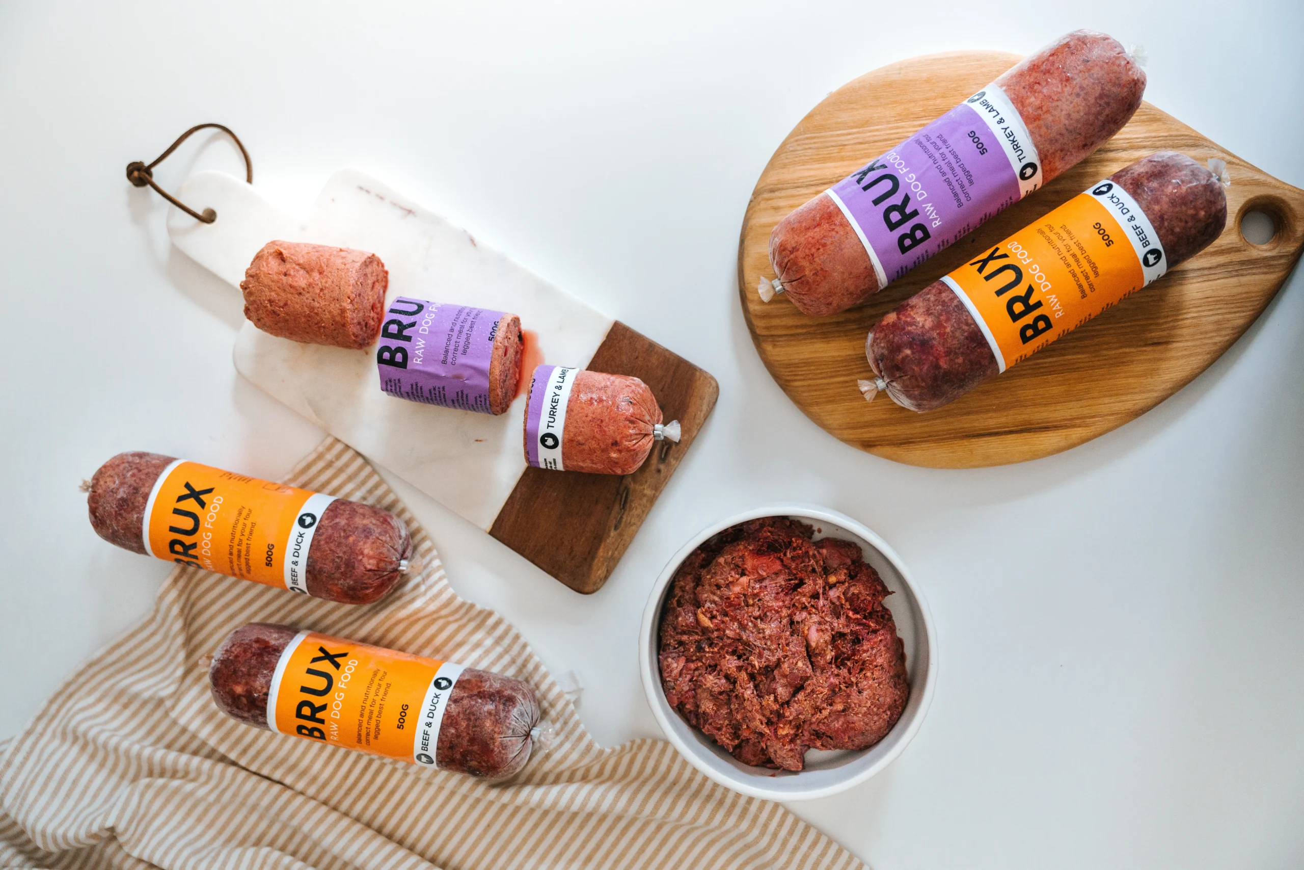 Table with BRUX raw dog food laid out, cut up and served